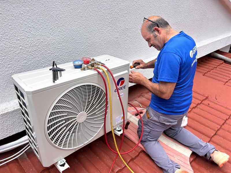 Técnico conectando unidad exterior en tejado
