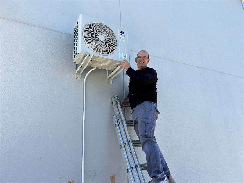 Instalador montando unidad exterior en fachada